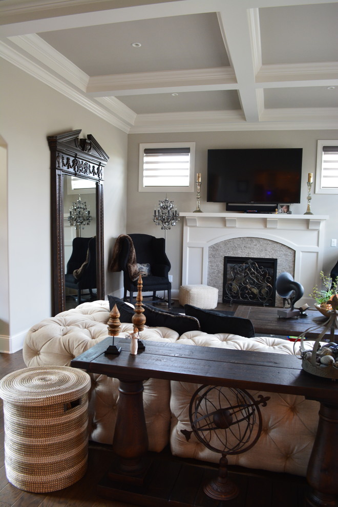 Imagen de salón abierto tradicional renovado grande con paredes grises, suelo de madera en tonos medios, todas las chimeneas, marco de chimenea de piedra y televisor colgado en la pared