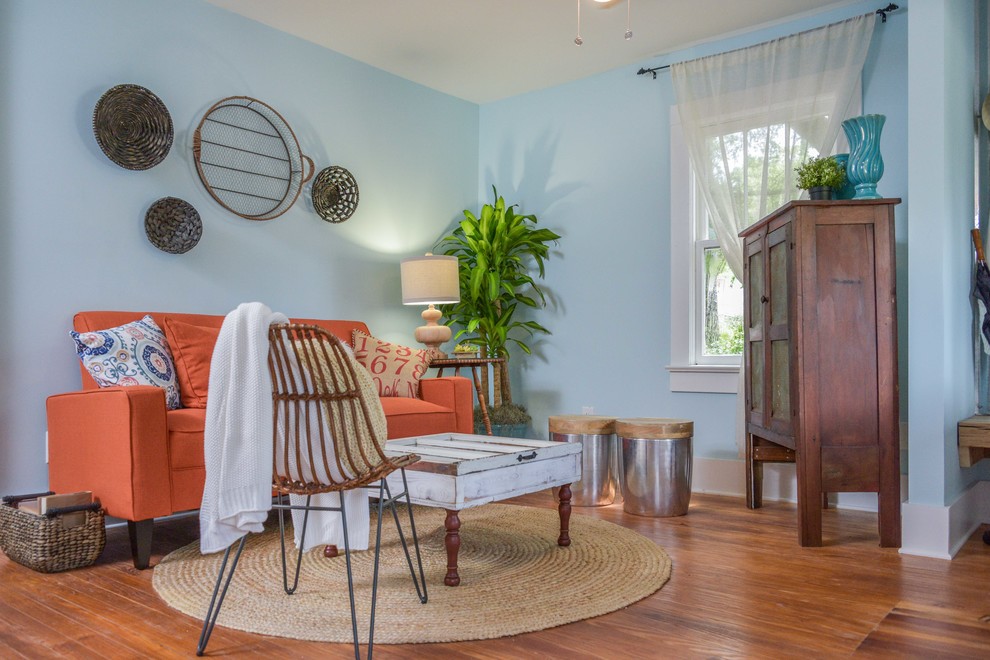 Immagine di un soggiorno eclettico di medie dimensioni e chiuso con pareti blu, pavimento in legno massello medio, nessuna TV e pavimento marrone