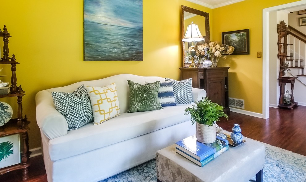 Idee per un soggiorno chic di medie dimensioni e chiuso con pareti gialle e pavimento in legno massello medio