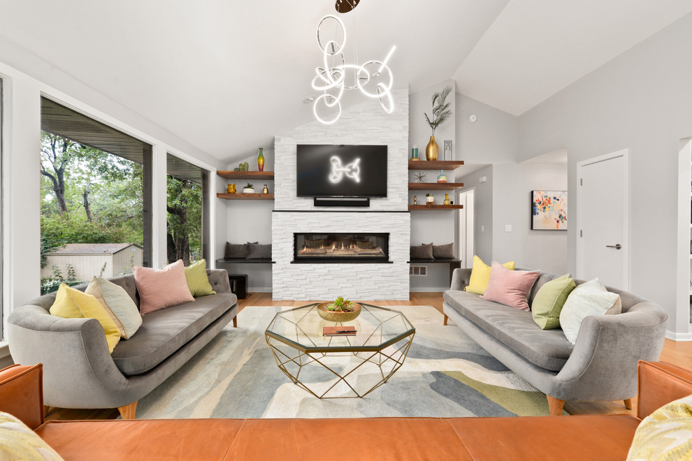 Example of a mid-sized mid-century modern open concept medium tone wood floor living room design in Kansas City with white walls, a ribbon fireplace, a tile fireplace and a wall-mounted tv