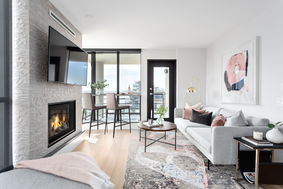 Inspiration for a small contemporary open plan living room in Vancouver with a home bar, white walls, light hardwood flooring, a standard fireplace, a tiled fireplace surround and a wall mounted tv.
