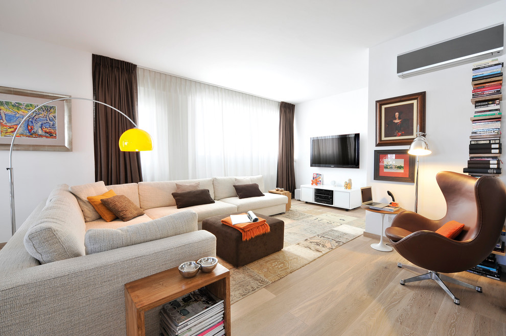 Esempio di un soggiorno contemporaneo aperto con pareti bianche, pavimento in legno massello medio e TV a parete