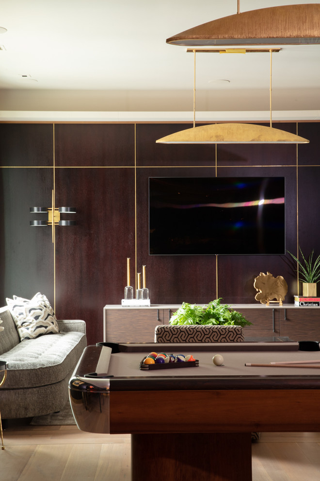 Diseño de salón con barra de bar cerrado tradicional grande con paredes negras, suelo de madera clara, televisor colgado en la pared y suelo beige