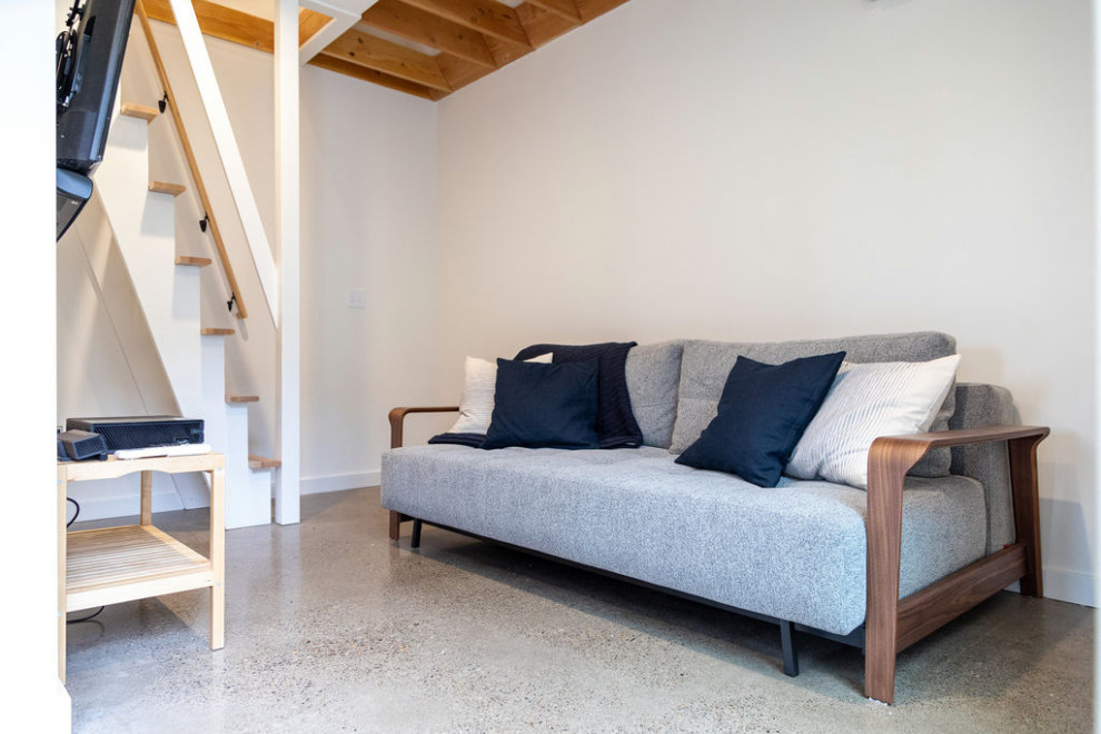 Идея дизайна: маленькая открытая гостиная комната в современном стиле с белыми стенами, бетонным полом, телевизором на стене и серым полом для на участке и в саду