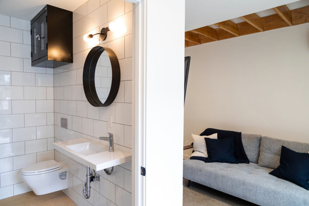 Immagine di un piccolo soggiorno minimal aperto con pareti bianche, pavimento in cemento, TV a parete e pavimento grigio