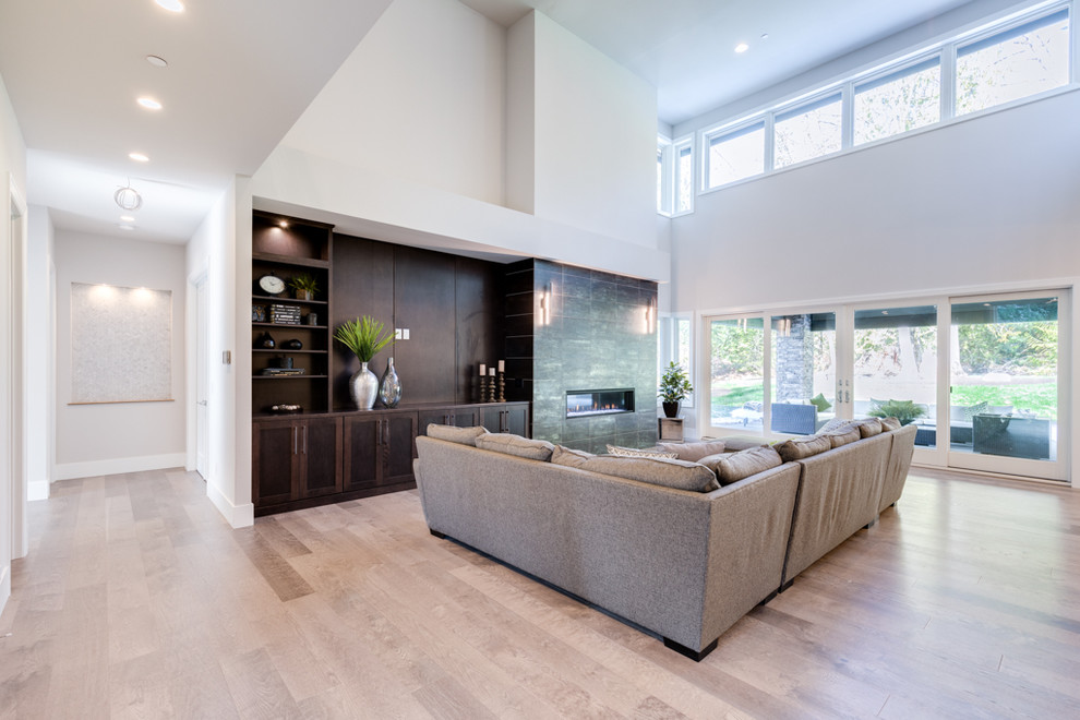 Medium sized contemporary formal open plan living room in Seattle with beige walls, light hardwood flooring, a ribbon fireplace, a tiled fireplace surround, no tv and beige floors.