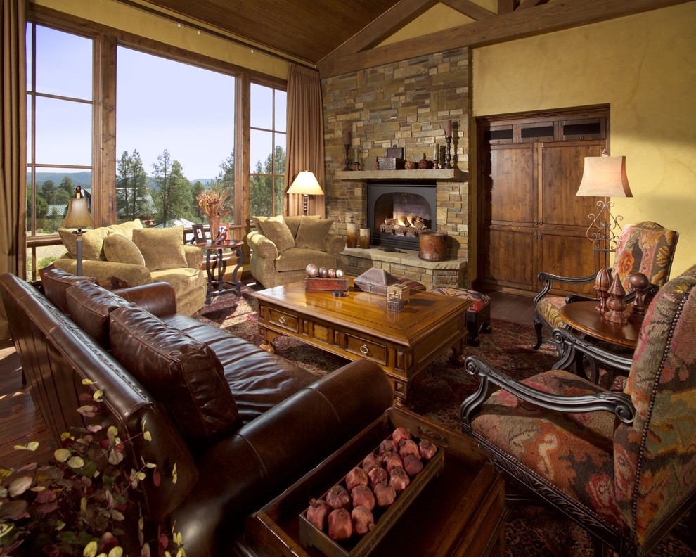 Huge tuscan formal and open concept medium tone wood floor living room photo in Phoenix with a standard fireplace, a stone fireplace, yellow walls and a concealed tv