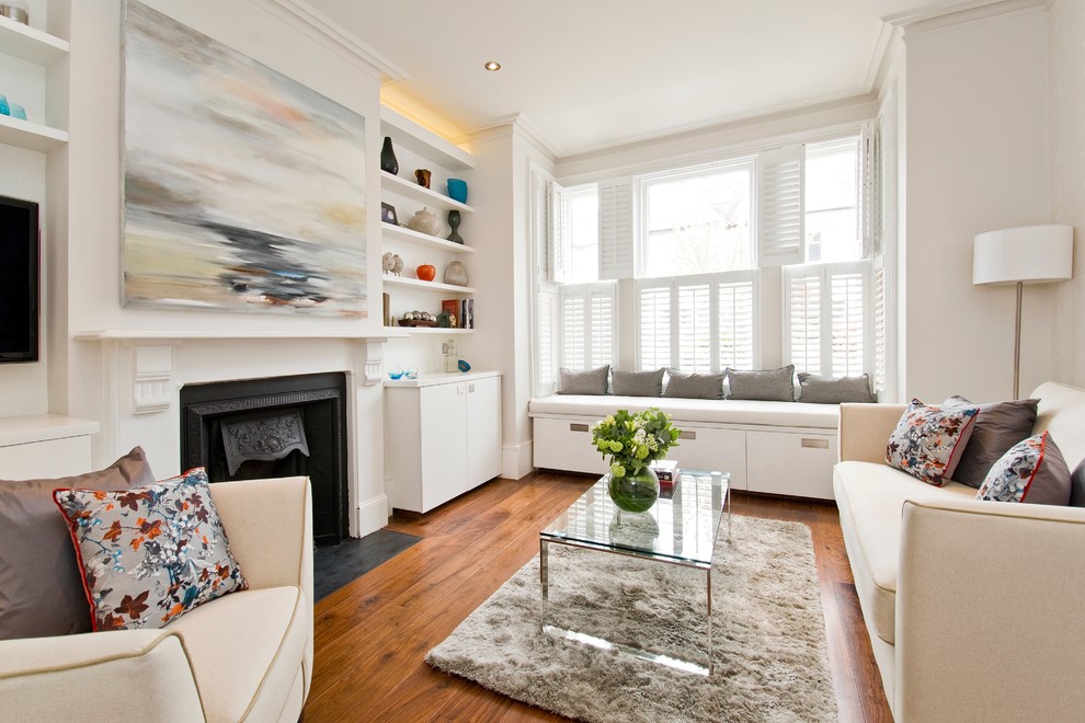 Esempio di un soggiorno classico con pareti bianche, pavimento in legno massello medio e camino classico