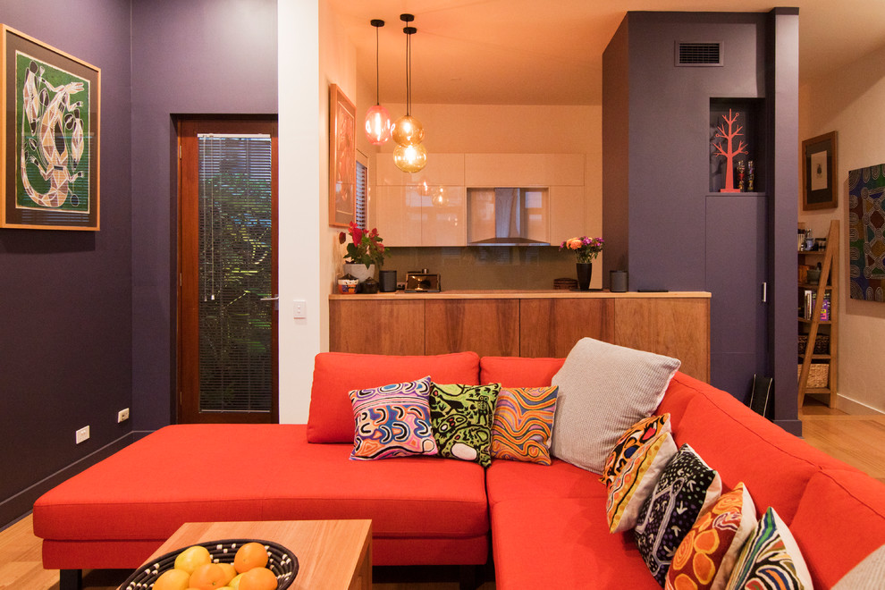 Immagine di un piccolo soggiorno design aperto con pareti viola e parquet chiaro