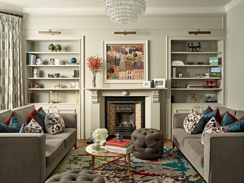 Пример оригинального дизайна: парадная гостиная комната в стиле неоклассика (современная классика) с серыми стенами, паркетным полом среднего тона, стандартным камином и коричневым полом без телевизора