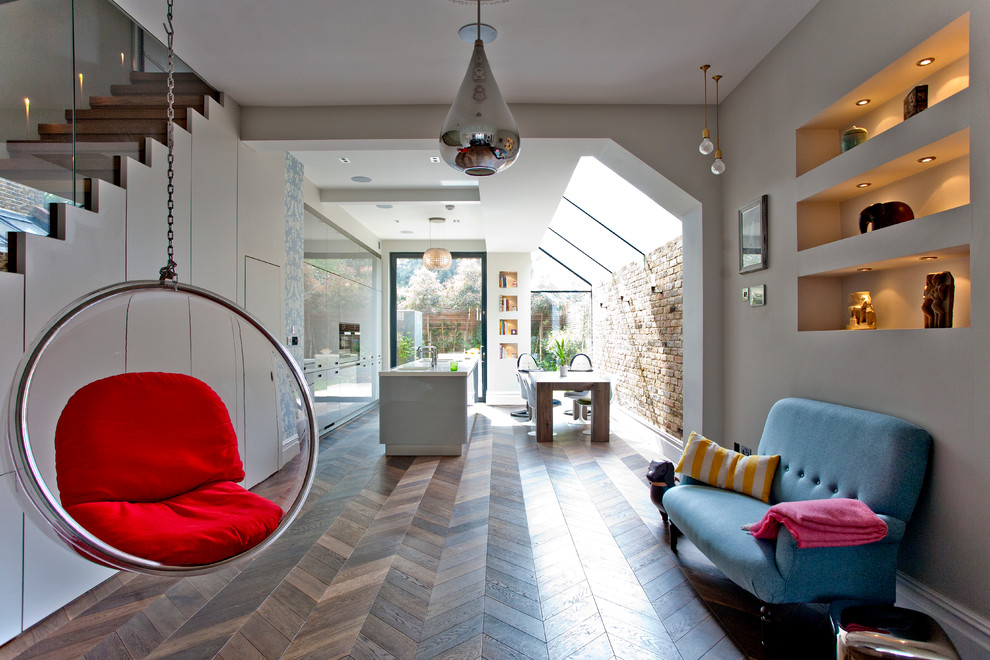 Foto di un soggiorno moderno aperto con pareti grigie e parquet chiaro