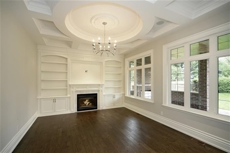 This is an example of a classic living room in Toronto with white walls, dark hardwood flooring and a standard fireplace.