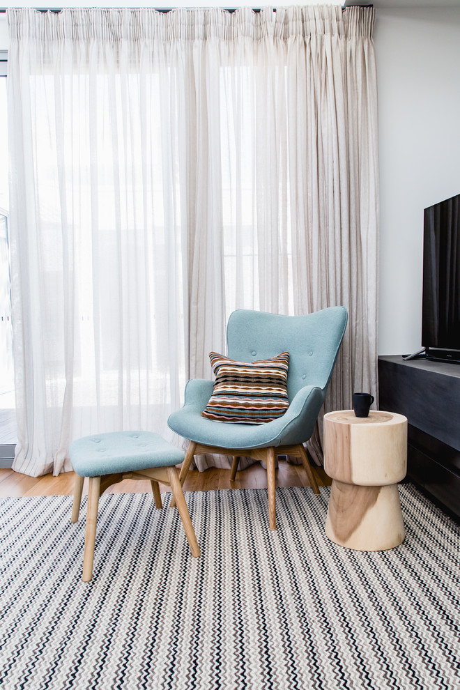 Mittelgroßes, Abgetrenntes Modernes Wohnzimmer mit weißer Wandfarbe, braunem Holzboden, freistehendem TV und braunem Boden in Melbourne