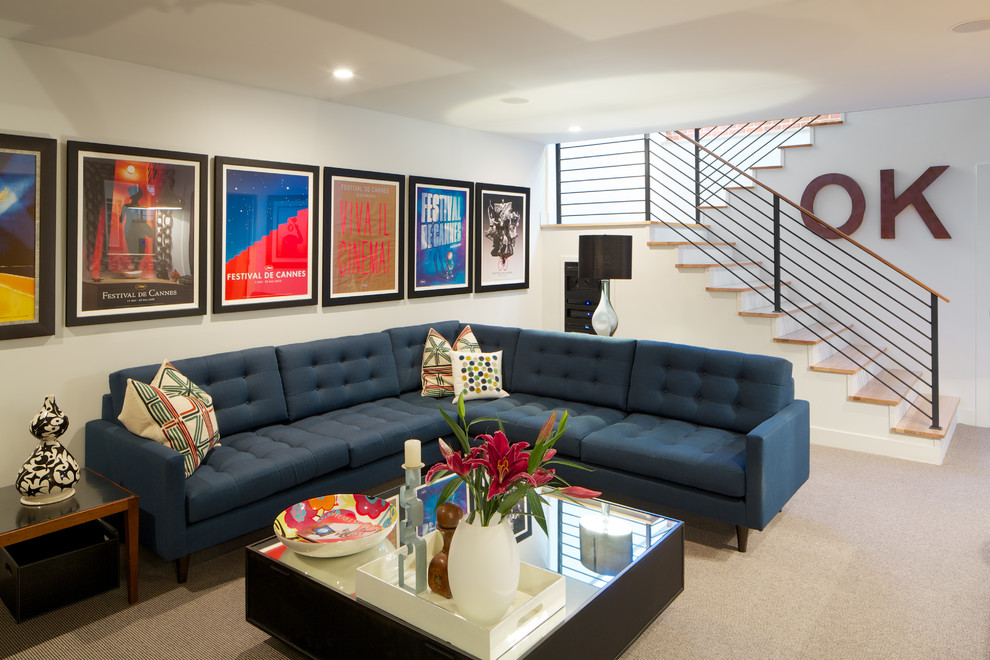 На фото: гостиная комната в современном стиле с белыми стенами, ковровым покрытием и синим диваном