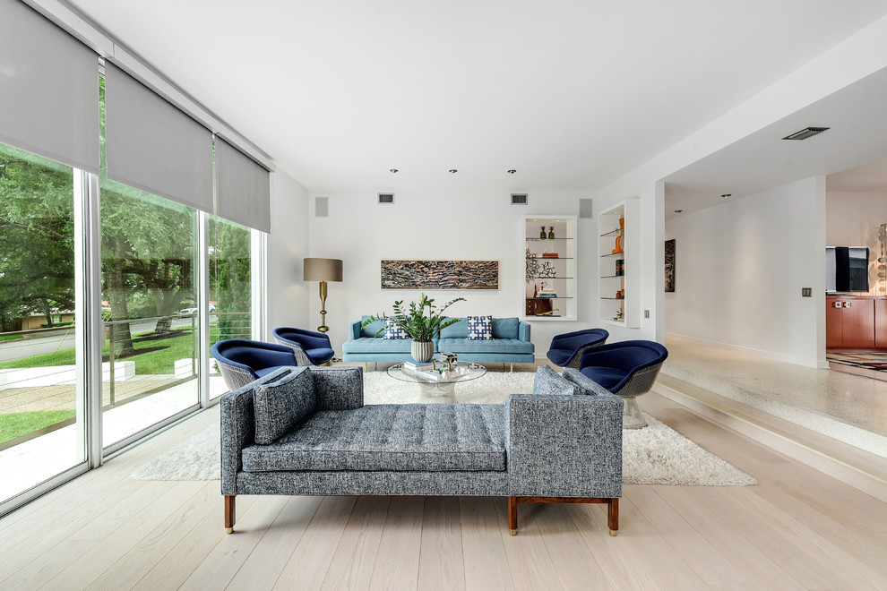 Ispirazione per un soggiorno design aperto con pareti bianche, parquet chiaro e pavimento beige