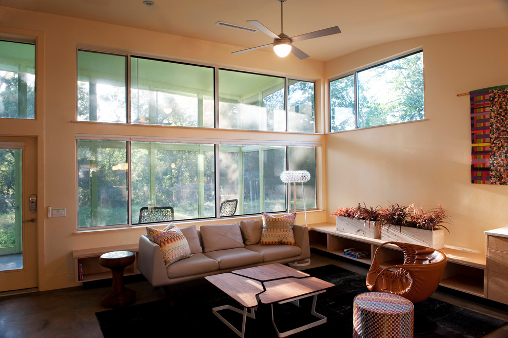Mittelgroßes, Repräsentatives, Offenes Modernes Wohnzimmer mit Betonboden, oranger Wandfarbe und Multimediawand in Austin