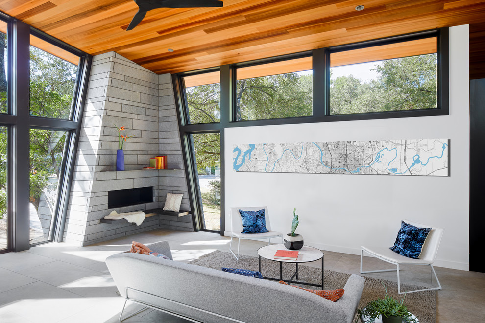 Mid-century modern open concept ceramic tile and gray floor living room photo in Austin with a corner fireplace, a stone fireplace and white walls