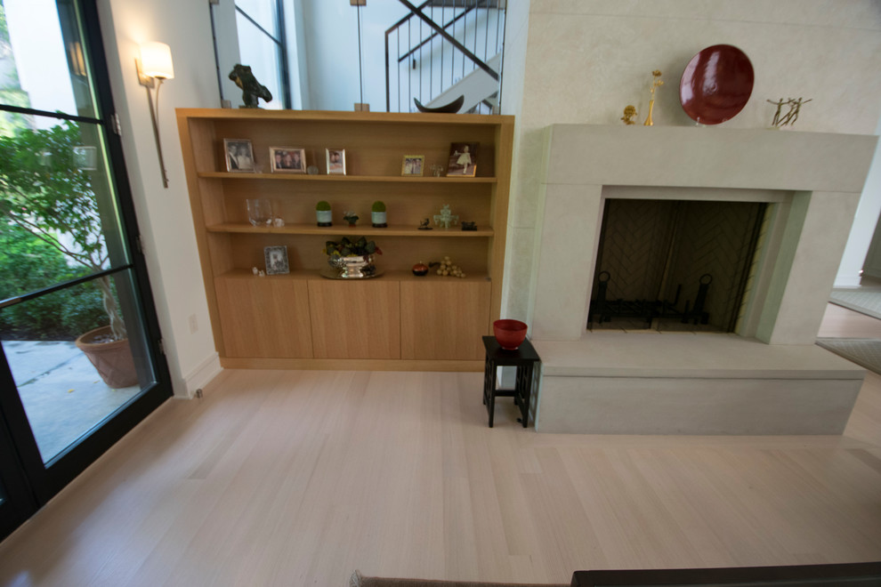 Bild på ett mellanstort amerikanskt separat vardagsrum, med grå väggar, ljust trägolv, en standard öppen spis, en spiselkrans i sten, en väggmonterad TV och vitt golv