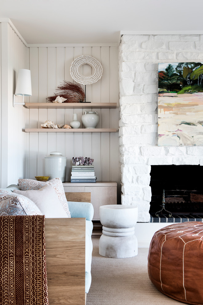 Mittelgroßes, Offenes Maritimes Wohnzimmer mit weißer Wandfarbe, Kamin, Teppichboden, Kaminumrandung aus Stein und beigem Boden in Sydney