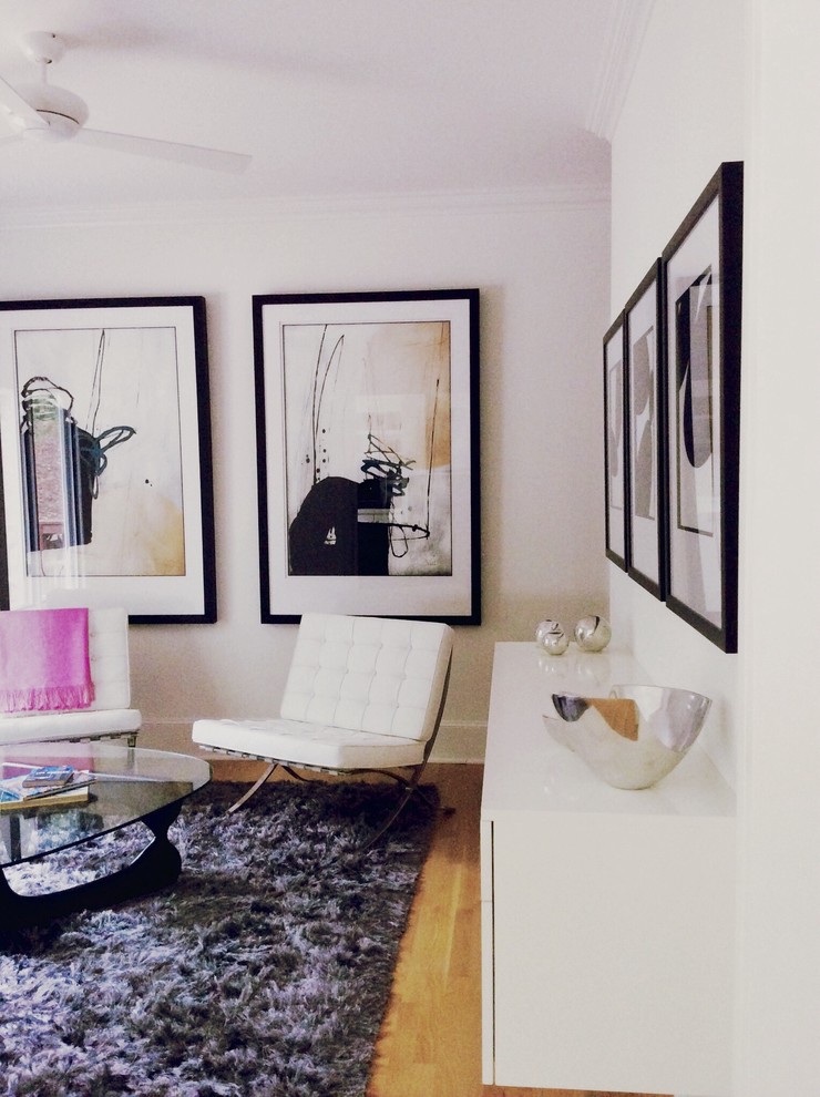 На фото: изолированная гостиная комната среднего размера в стиле модернизм с с книжными шкафами и полками, белыми стенами, светлым паркетным полом и серым полом без камина, телевизора