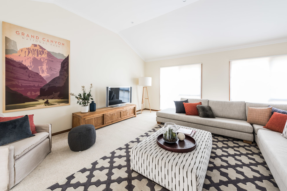 Идея дизайна: гостиная комната в современном стиле с бежевыми стенами, ковровым покрытием, отдельно стоящим телевизором и бежевым полом без камина