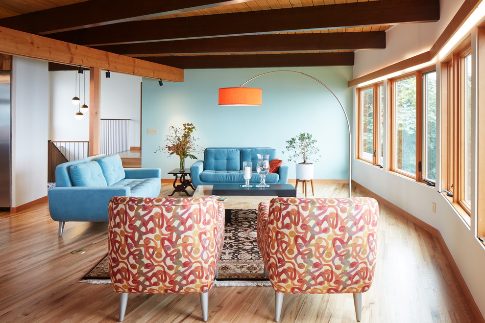 Esempio di un grande soggiorno design aperto con pareti blu, pavimento in legno massello medio e pavimento multicolore