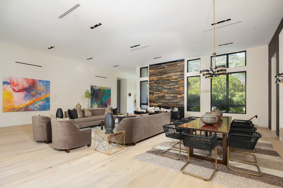 Expansive contemporary formal open plan living room in Los Angeles with white walls, light hardwood flooring, a ribbon fireplace, a stone fireplace surround, no tv and beige floors.
