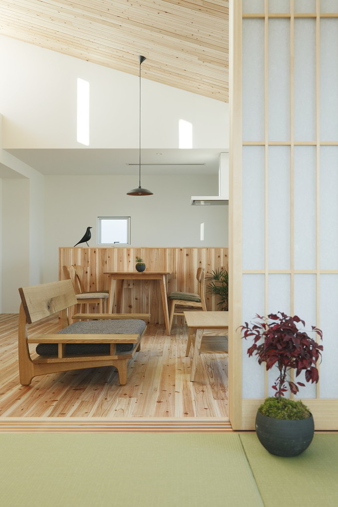 Свежая идея для дизайна: маленькая открытая гостиная комната в восточном стиле с белыми стенами, светлым паркетным полом, отдельно стоящим телевизором и бежевым полом для на участке и в саду - отличное фото интерьера