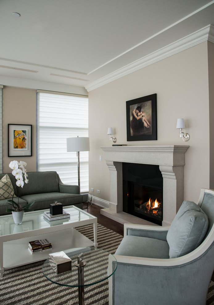 Photo of a large classic formal open plan living room in Toronto with beige walls, medium hardwood flooring, a standard fireplace, a stone fireplace surround and no tv.
