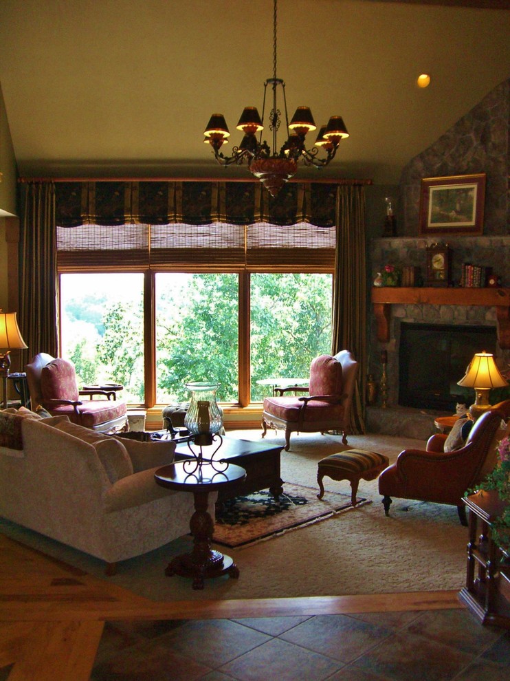На фото: большая двухуровневая гостиная комната в классическом стиле с зелеными стенами, ковровым покрытием, угловым камином, фасадом камина из камня и коричневым полом без телевизора с