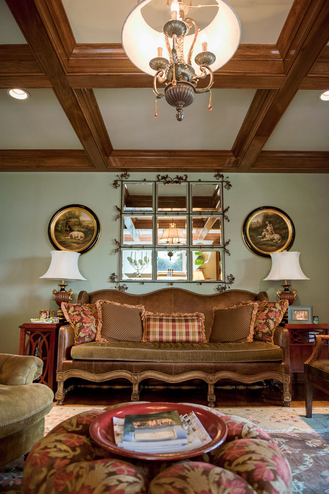 Cette image montre un grand salon traditionnel avec un mur vert, parquet clair, une cheminée standard, un manteau de cheminée en pierre et aucun téléviseur.