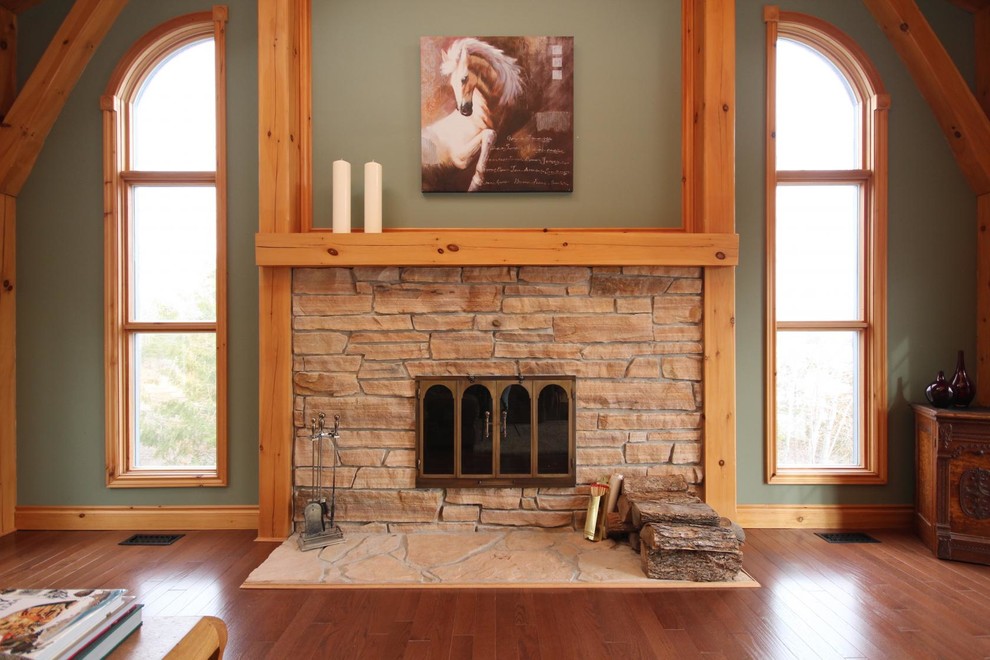 Photo of a large rustic open plan living room in Ottawa with green walls, medium hardwood flooring, a standard fireplace and a stone fireplace surround.
