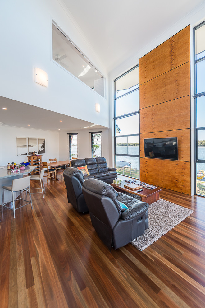 Foto di un ampio soggiorno contemporaneo aperto con pareti bianche, pavimento in legno massello medio e TV a parete