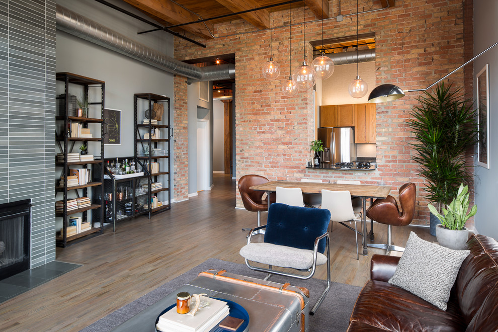 Aménagement d'un salon industriel de taille moyenne et ouvert avec un mur gris, parquet foncé et une cheminée standard.