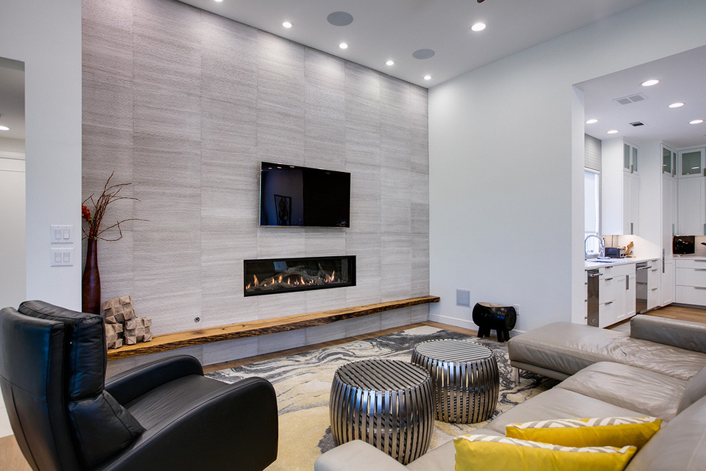 Großes, Repräsentatives, Offenes Modernes Wohnzimmer mit weißer Wandfarbe, hellem Holzboden, Gaskamin, gefliester Kaminumrandung und TV-Wand in Dallas