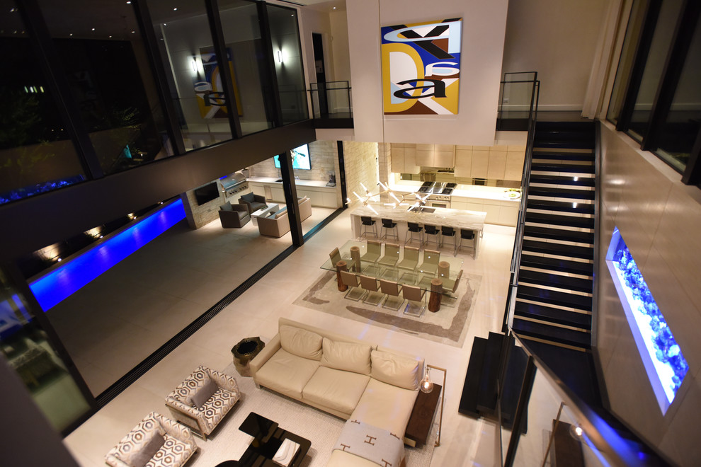 Immagine di un grande soggiorno minimalista aperto con pareti beige, pavimento in gres porcellanato, nessun camino e pavimento beige
