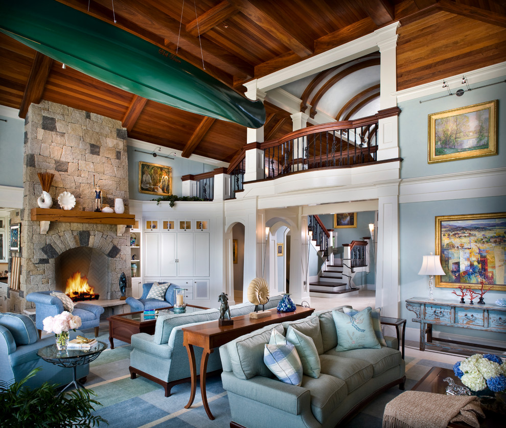 Esempio di un ampio soggiorno chic stile loft con sala formale, pareti blu, camino classico, cornice del camino in pietra, parquet scuro e TV nascosta