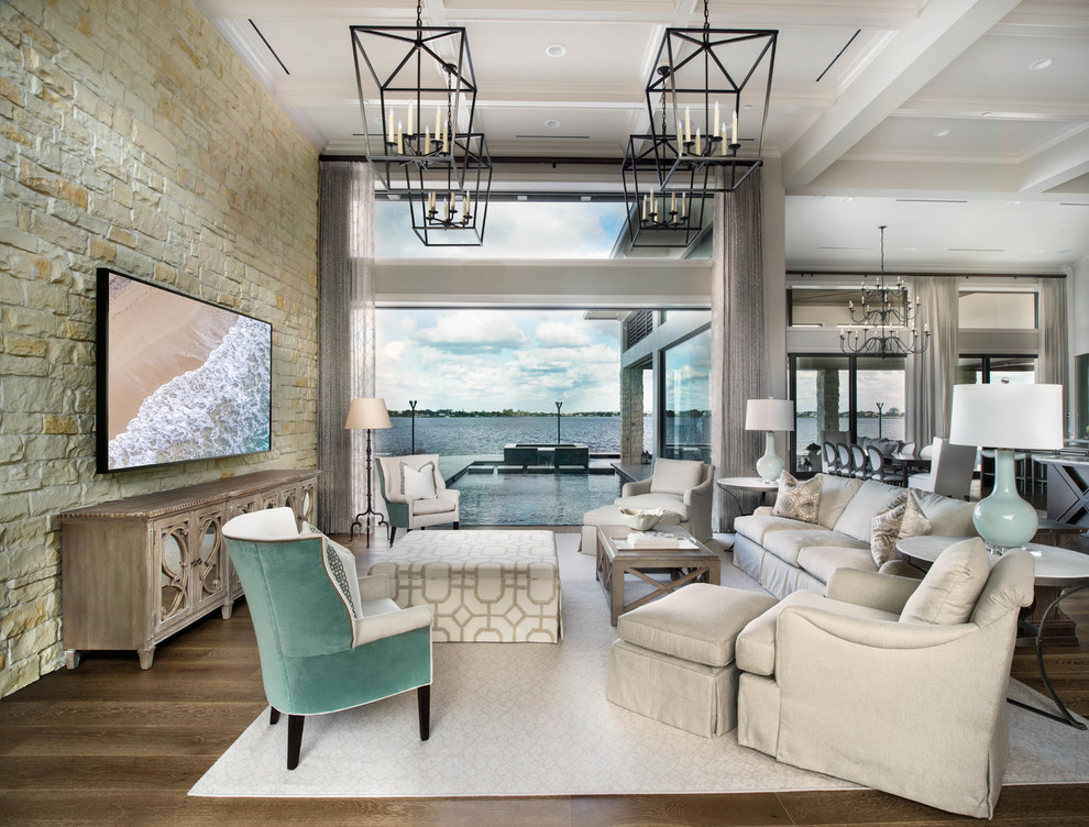 Geräumiges, Offenes Klassisches Wohnzimmer mit grauer Wandfarbe, braunem Boden, Steinwänden, braunem Holzboden, TV-Wand und Kassettendecke in Miami