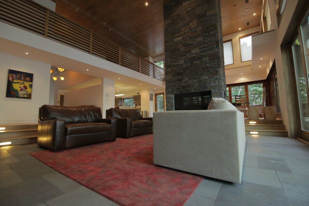 Immagine di un grande soggiorno design stile loft con pareti bianche, cornice del camino in pietra e TV nascosta