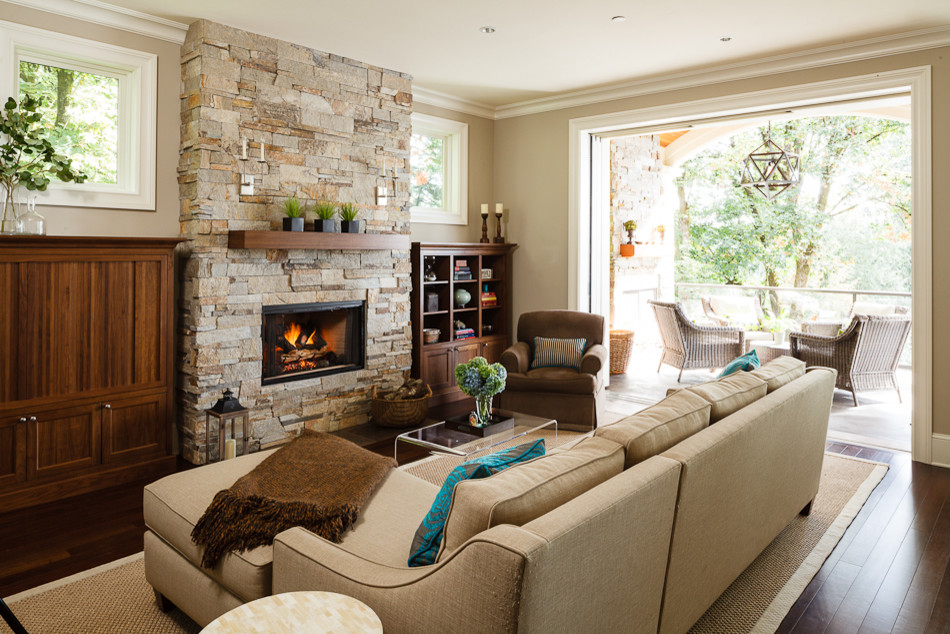 ポートランドにある高級な中くらいなトラディショナルスタイルのおしゃれなLDK (ベージュの壁、石材の暖炉まわり、横長型暖炉、濃色無垢フローリング、テレビなし、茶色い床) の写真
