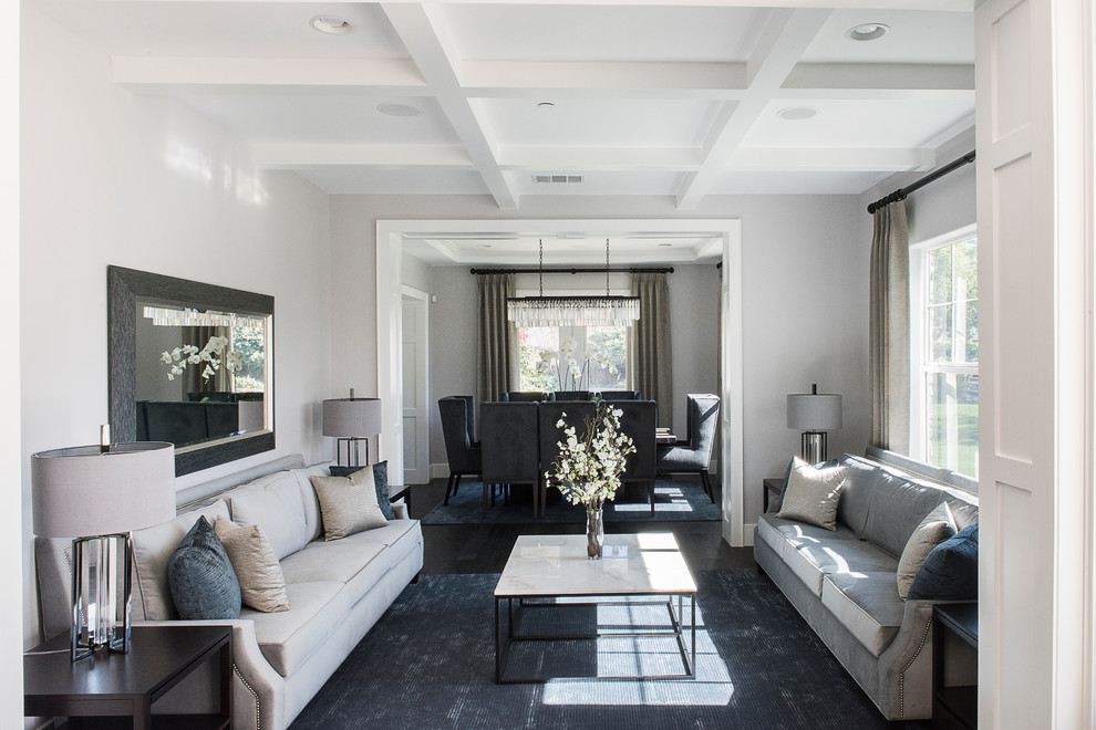 Cette image montre un salon design de taille moyenne et fermé avec un mur gris, parquet foncé et un sol marron.