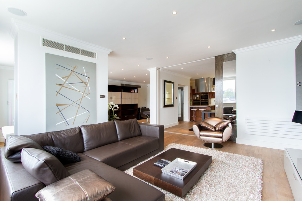 Стильный дизайн: гостиная комната в стиле модернизм с белыми стенами и коричневым диваном - последний тренд