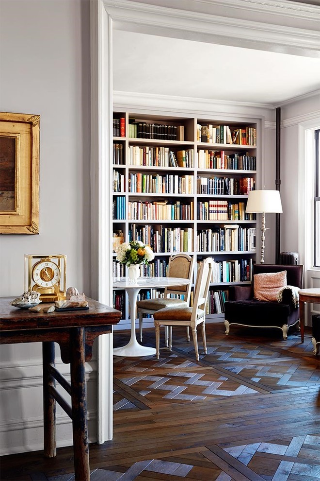 Exemple d'un grand salon chic ouvert avec une bibliothèque ou un coin lecture, un mur gris et un sol en bois brun.