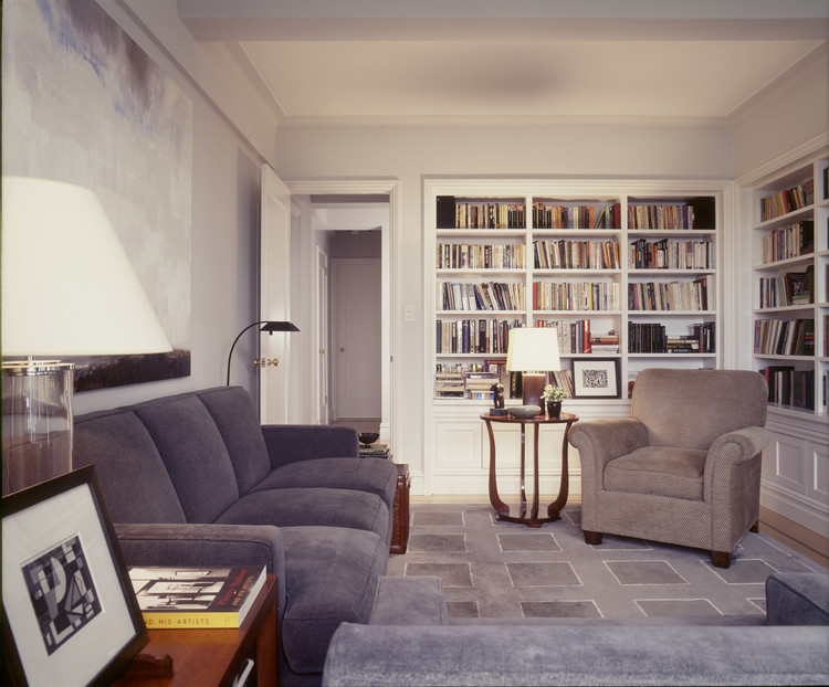 Imagen de biblioteca en casa cerrada tradicional renovada de tamaño medio sin televisor con paredes blancas y suelo de madera clara