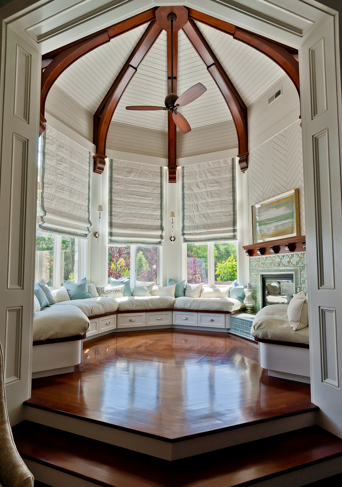 Photo of a medium sized traditional enclosed living room in Salt Lake City with medium hardwood flooring, white walls, a standard fireplace, a tiled fireplace surround and brown floors.