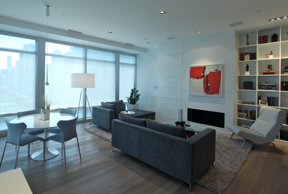Foto di un soggiorno moderno di medie dimensioni e aperto con pareti bianche, parquet chiaro, camino classico, cornice del camino in intonaco e TV nascosta