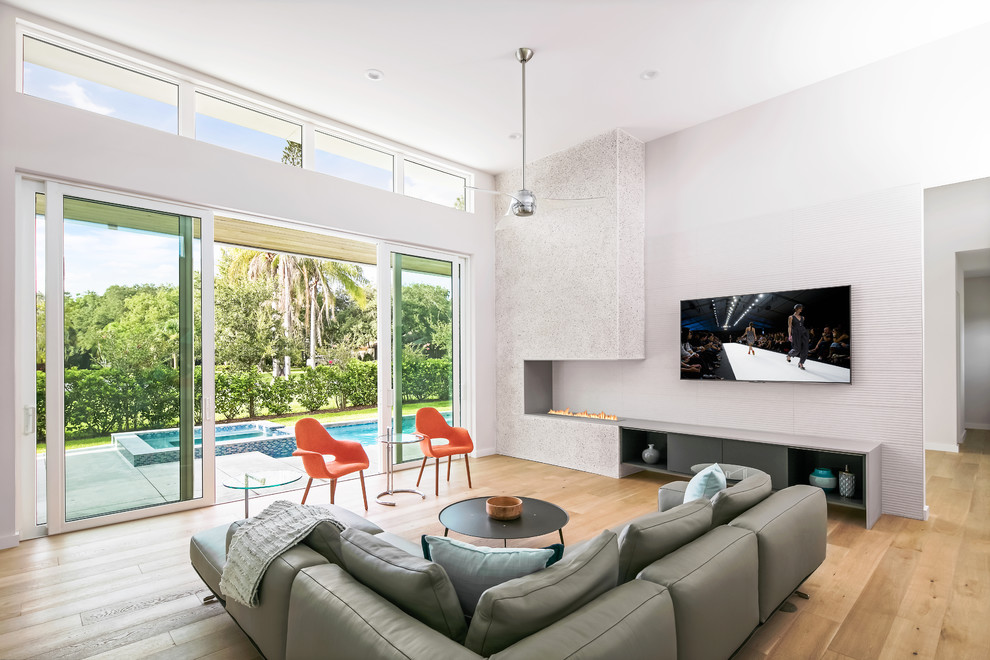 Идея дизайна: открытая гостиная комната среднего размера в современном стиле с белыми стенами, светлым паркетным полом, горизонтальным камином, фасадом камина из бетона, телевизором на стене и бежевым полом