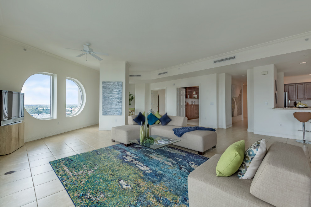 Foto de salón moderno extra grande con paredes blancas, suelo de baldosas de porcelana, televisor independiente y suelo beige