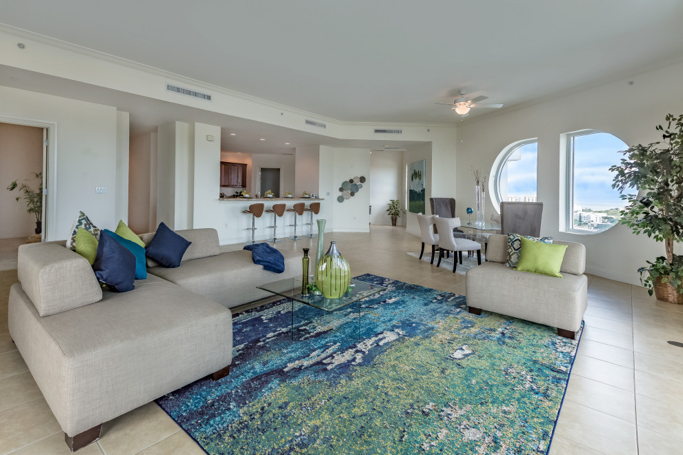 Großes, Offenes Modernes Wohnzimmer mit weißer Wandfarbe, Travertin, freistehendem TV und beigem Boden in Tampa