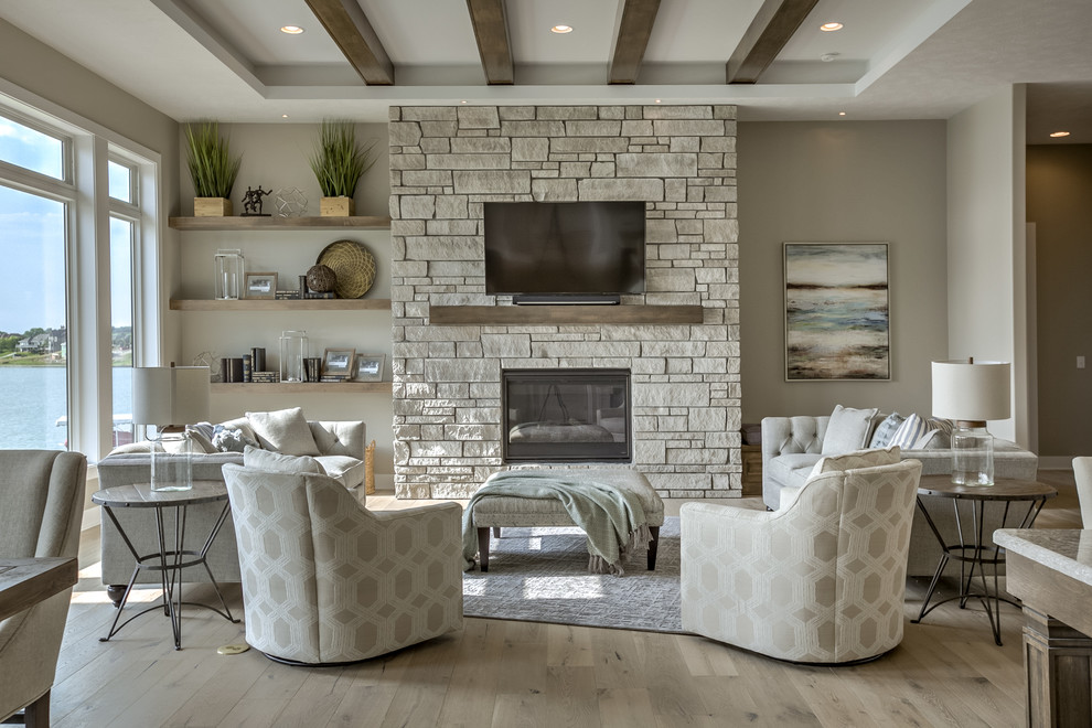 This is an example of a medium sized traditional formal open plan living room in Omaha with beige walls, medium hardwood flooring, a standard fireplace, a stone fireplace surround, a wall mounted tv and beige floors.